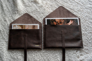 Leather print envelopes holding deckled edge prints.
